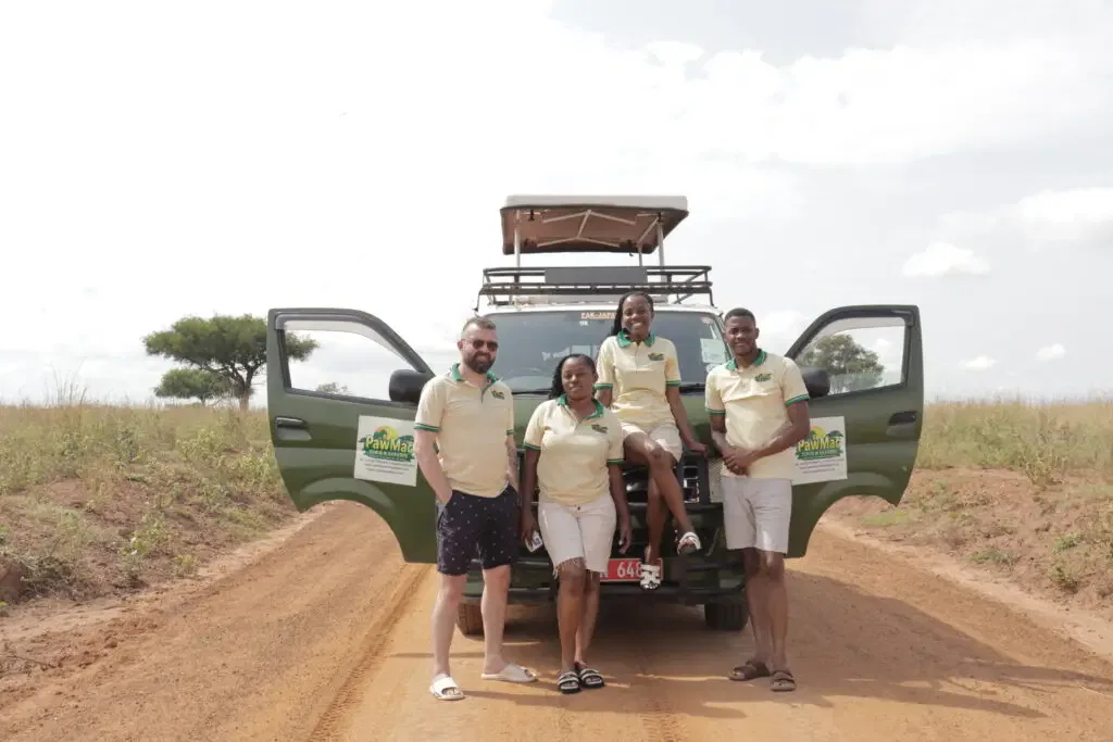 PawMac Safaris team with safari vehicle in Queen Elizabeth National Park Uganda
