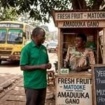 Travelers using English and Luganda at Kampala kiosk