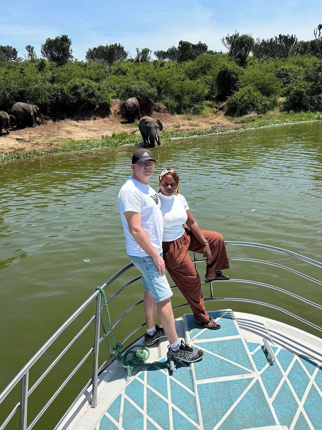 PawMac Safaris guests on a boat cruise encountering a wild elephant on the banks of Kazinga Channel, Uganda