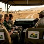 Safari jeep and travelers exploring African savanna