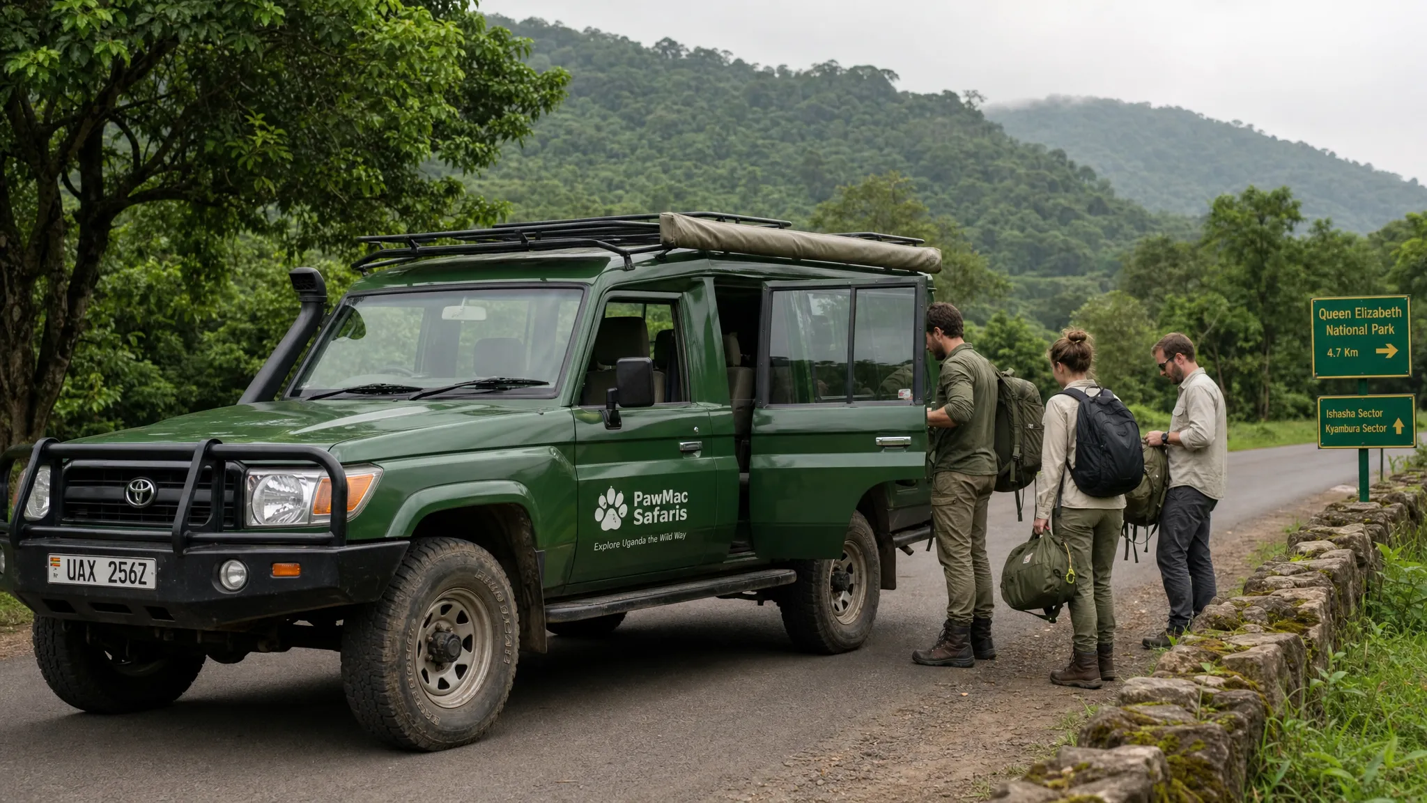 A PawMac Safaris 4x4 vehicle paused on a quiet Ugandan park road, with forested hills behind it and adult travelers loading day bags before a guided wildlife transfer.