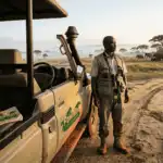 Safari guide and vehicle at dawn in Uganda