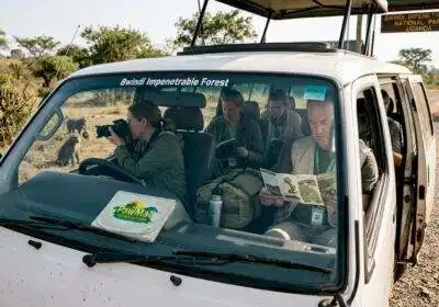 Travelers in safari van at park entrance Uganda